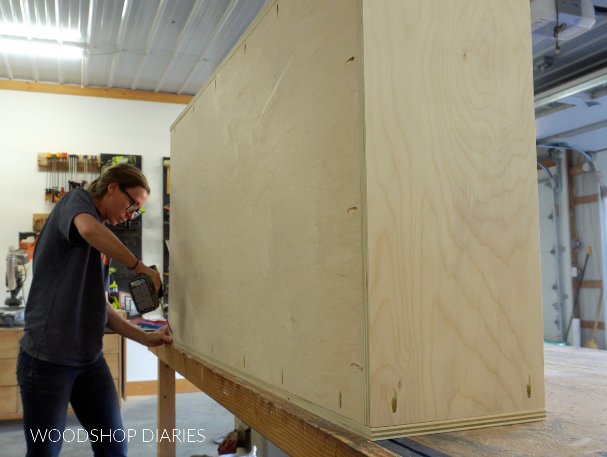 Shara Woodshop Diaries installing large plywood back panel into bookcase