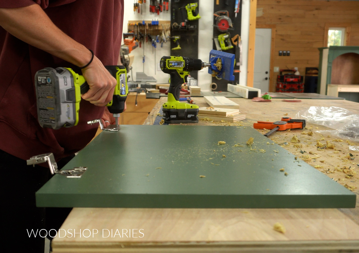Shara Woodshop Diaries installing concealed hinges onto cabinet doors on workbench