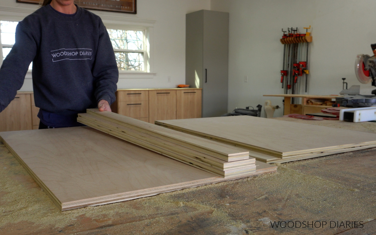 Shara Woodshop Diaries placing plywood pieces to assemble DIY blind corner cabinet on workbench