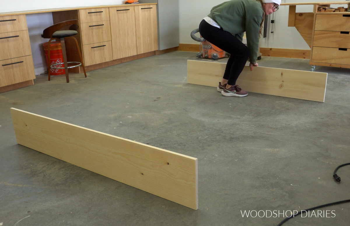 Shara Woodshop Diaries placing head and footboard pieces for platform storage bed on workshop floor