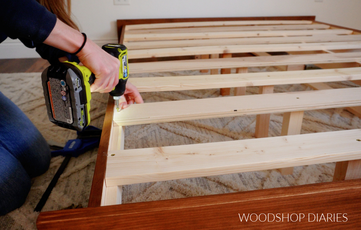 Shara Woodshop Diaries installing bed slats onto side rails of platform bed frame