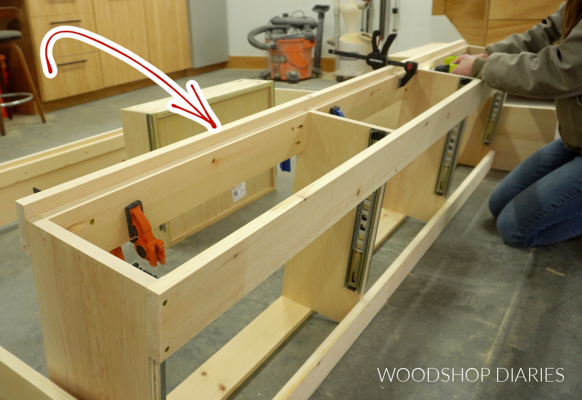 Shara Woodshop Diaries securing top trim piece onto storage platform bed frame
