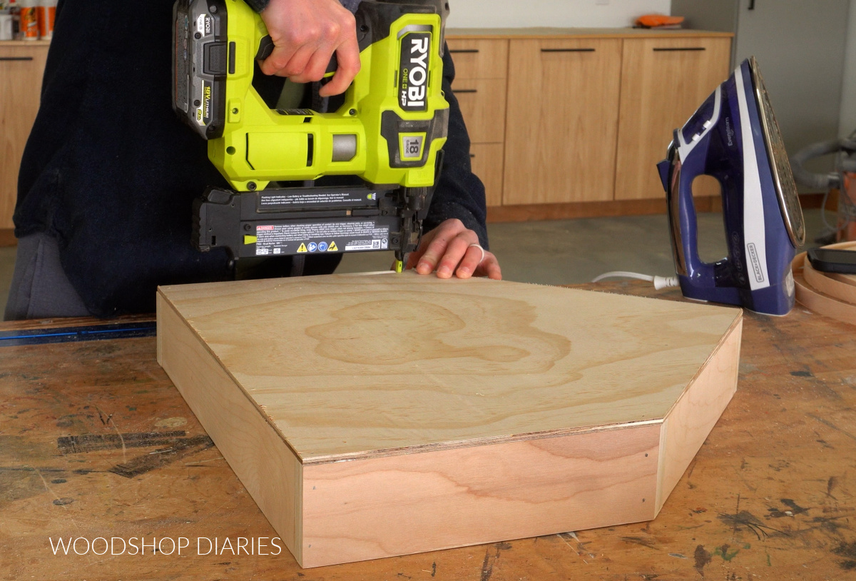 Shara Woodshop Diaries nailing drawer bottom onto drawer box with brad nailer