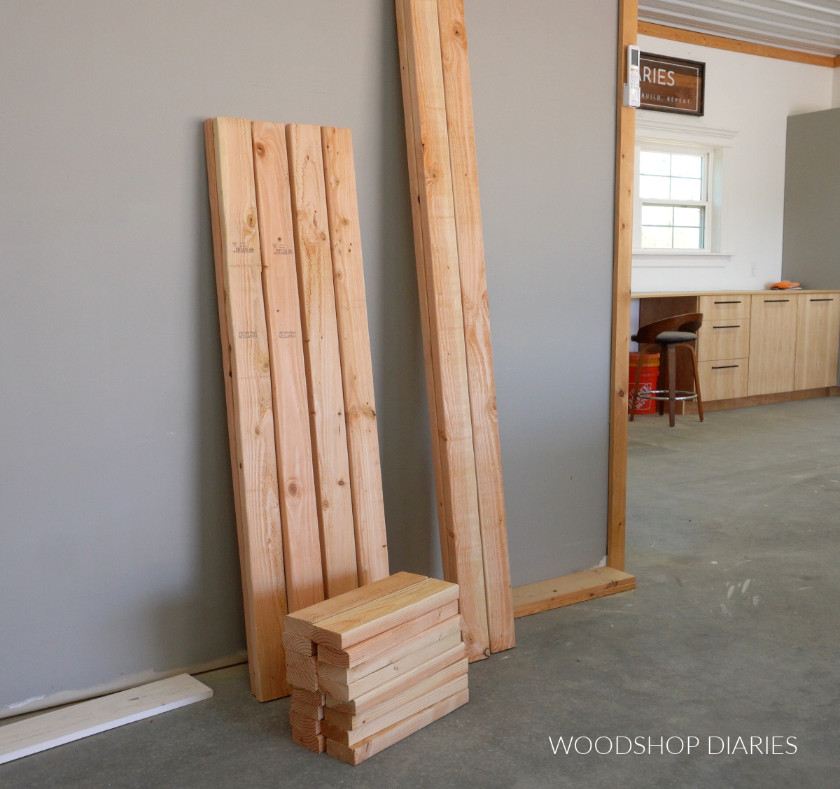 2x4s cut to length for garage shelf leaning against wall in workshop