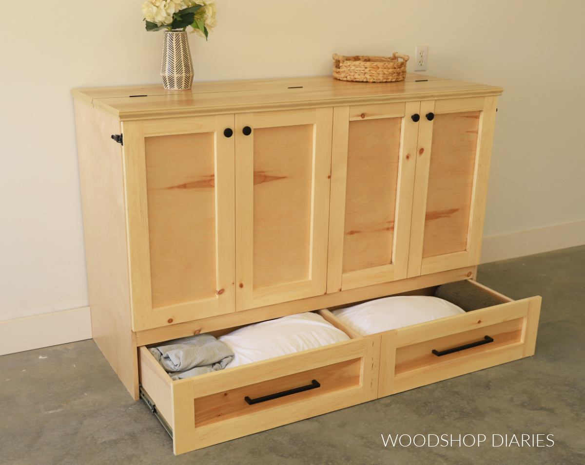 DIY Murphy bed cabinet with bottom drawer open to show bedding stored inside