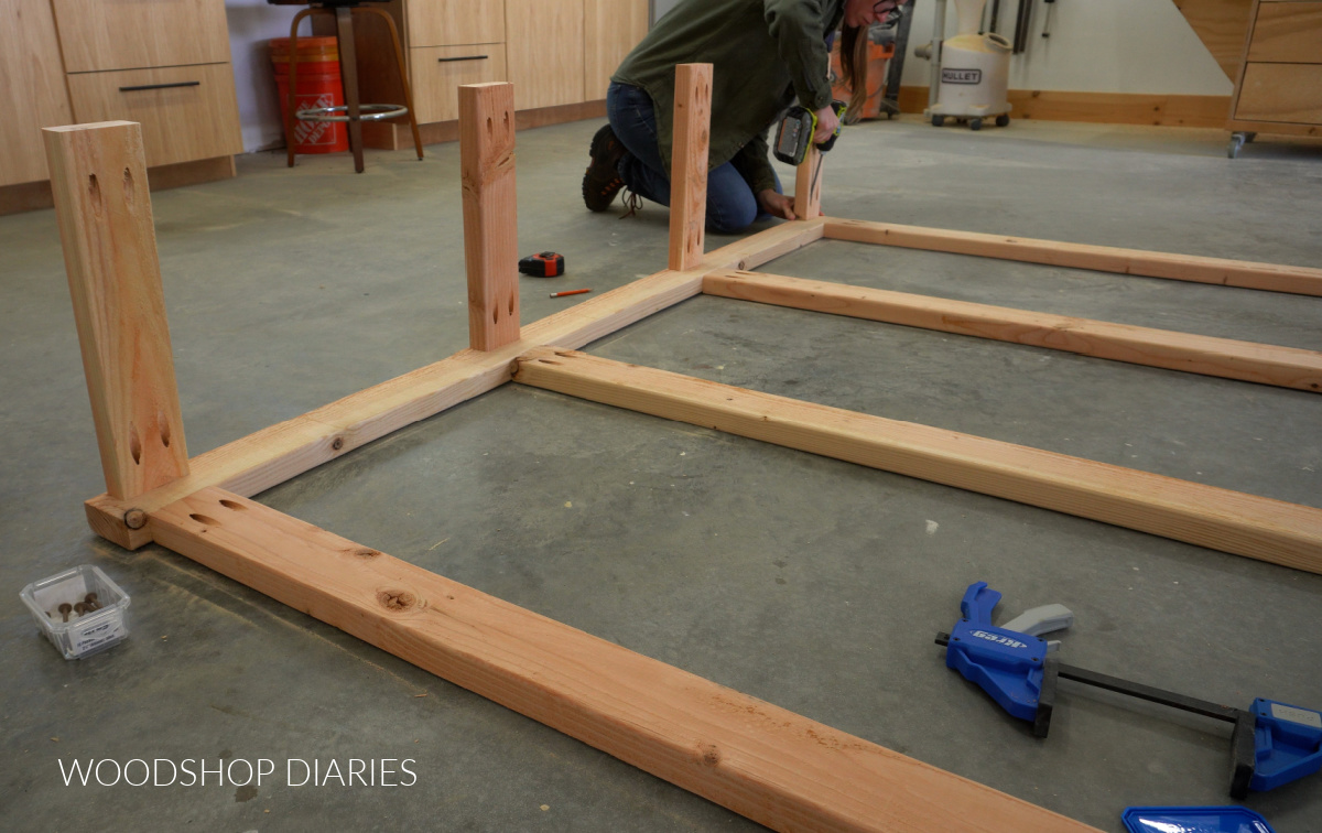 Shara Woodshop Diaries installing the shelf side supports onto garage shelf frame with pocket hole screws