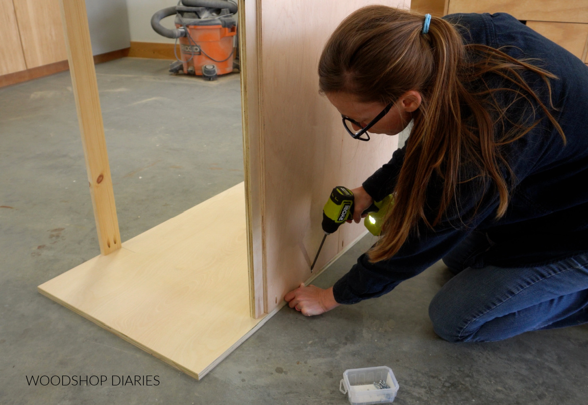 Shara Woodshop Diaries assembling back panel of DIY murphy bed cabinet on shop floor with pocket holes