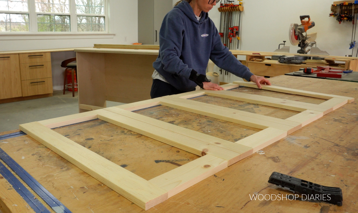 Shara Woodshop Diaries laying out faux door frames on workbench
