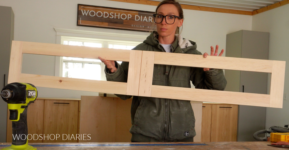Shara Woodshop Diaries holding up large frame that looks like two drawer fronts