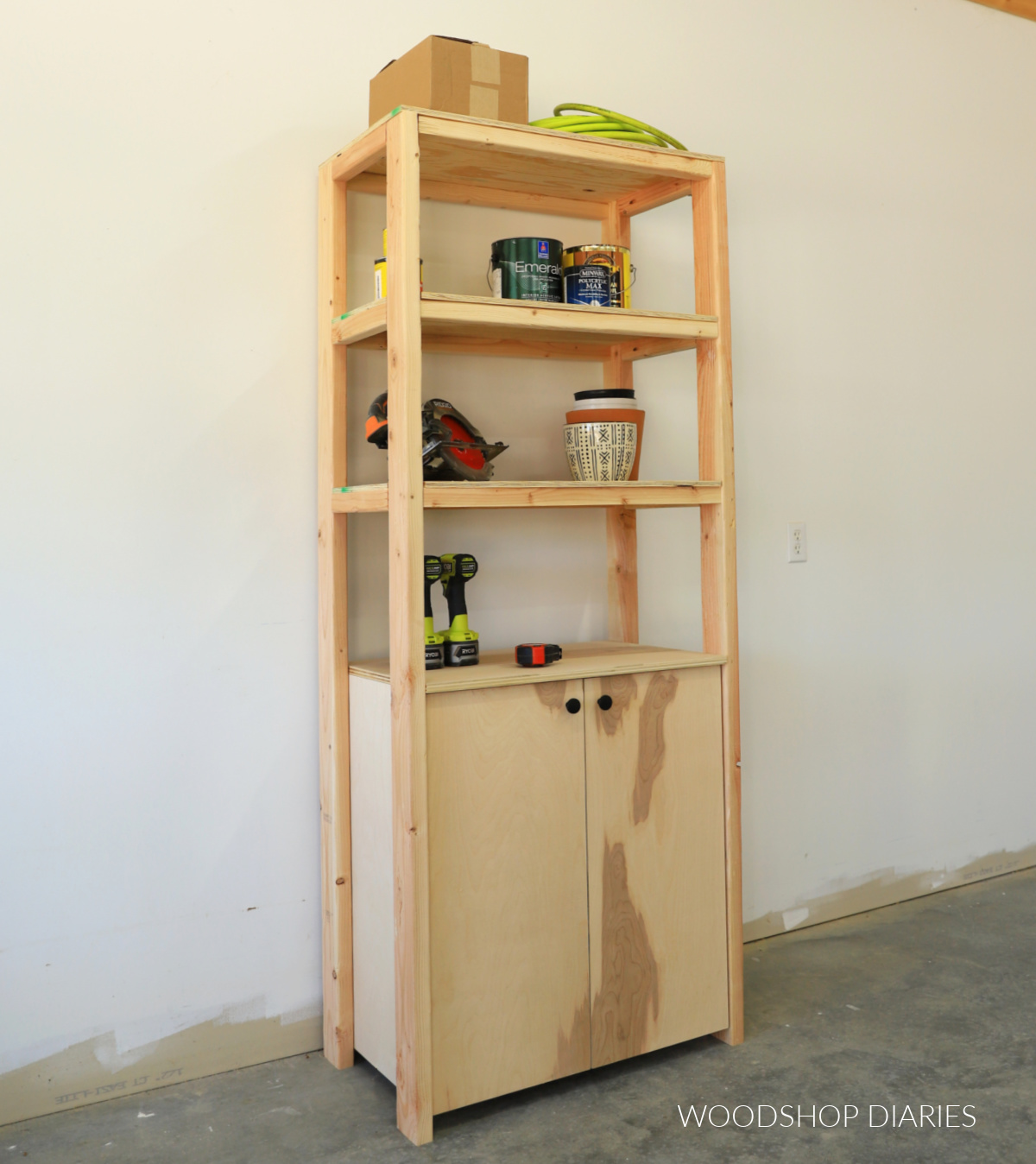 Garage shelf with built in cabinet on bottom--paint and tools on three tier shelves above cabinet