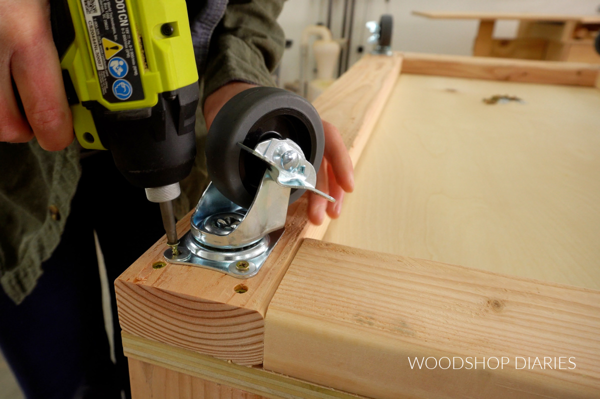 Close up of installing caster wheels on bottom of workbench frame