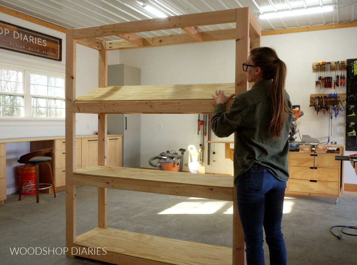 Shara Woodshop Diaries placing plywood shelves into garage shelf frame