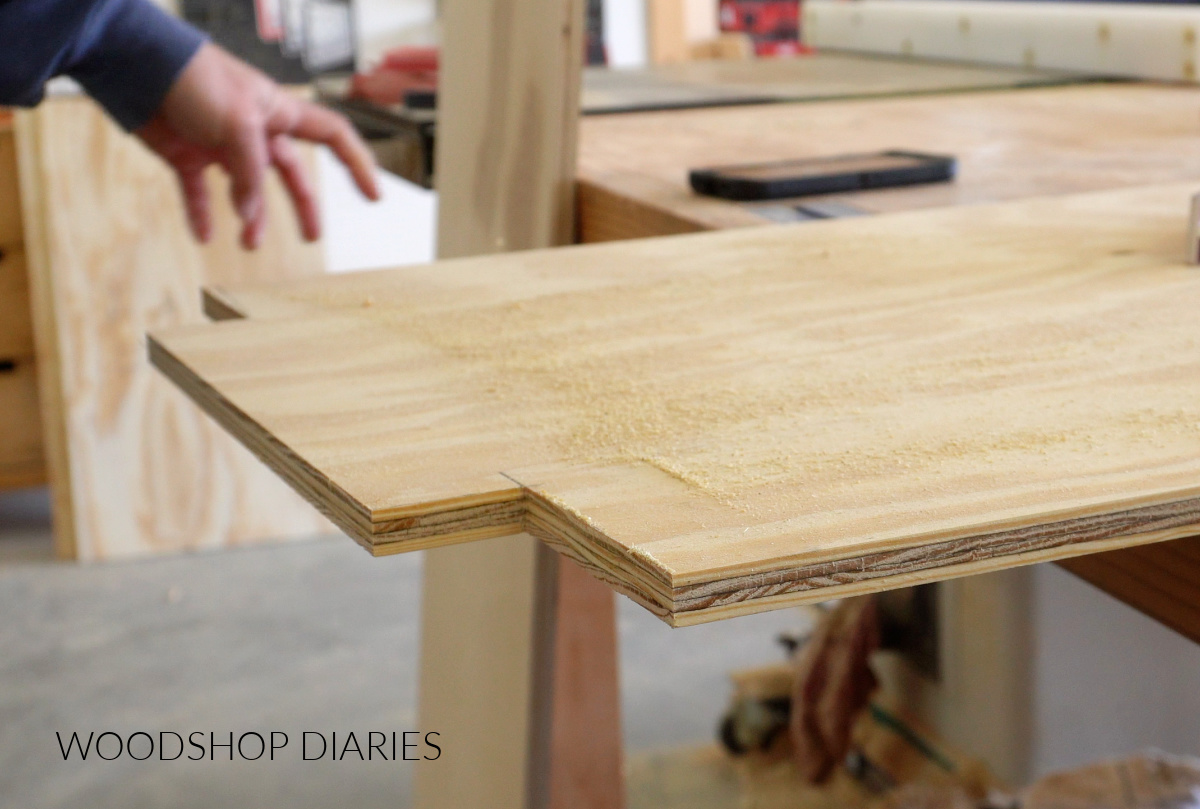 Close up of notches cut on corner of plywood shelves