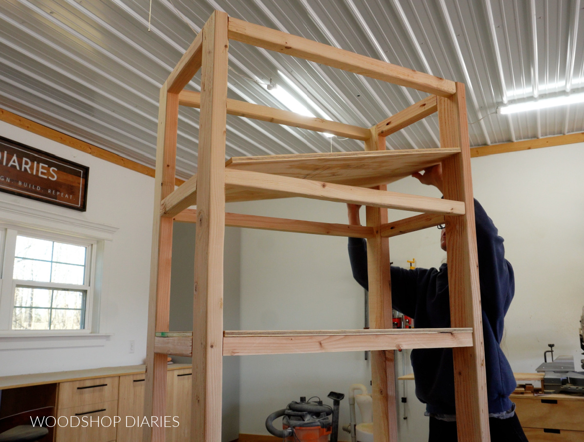 Shara Woodshop Diaries placing ½" plywood shelves onto 2x2 shelf frame in garage shelf with cabinet project