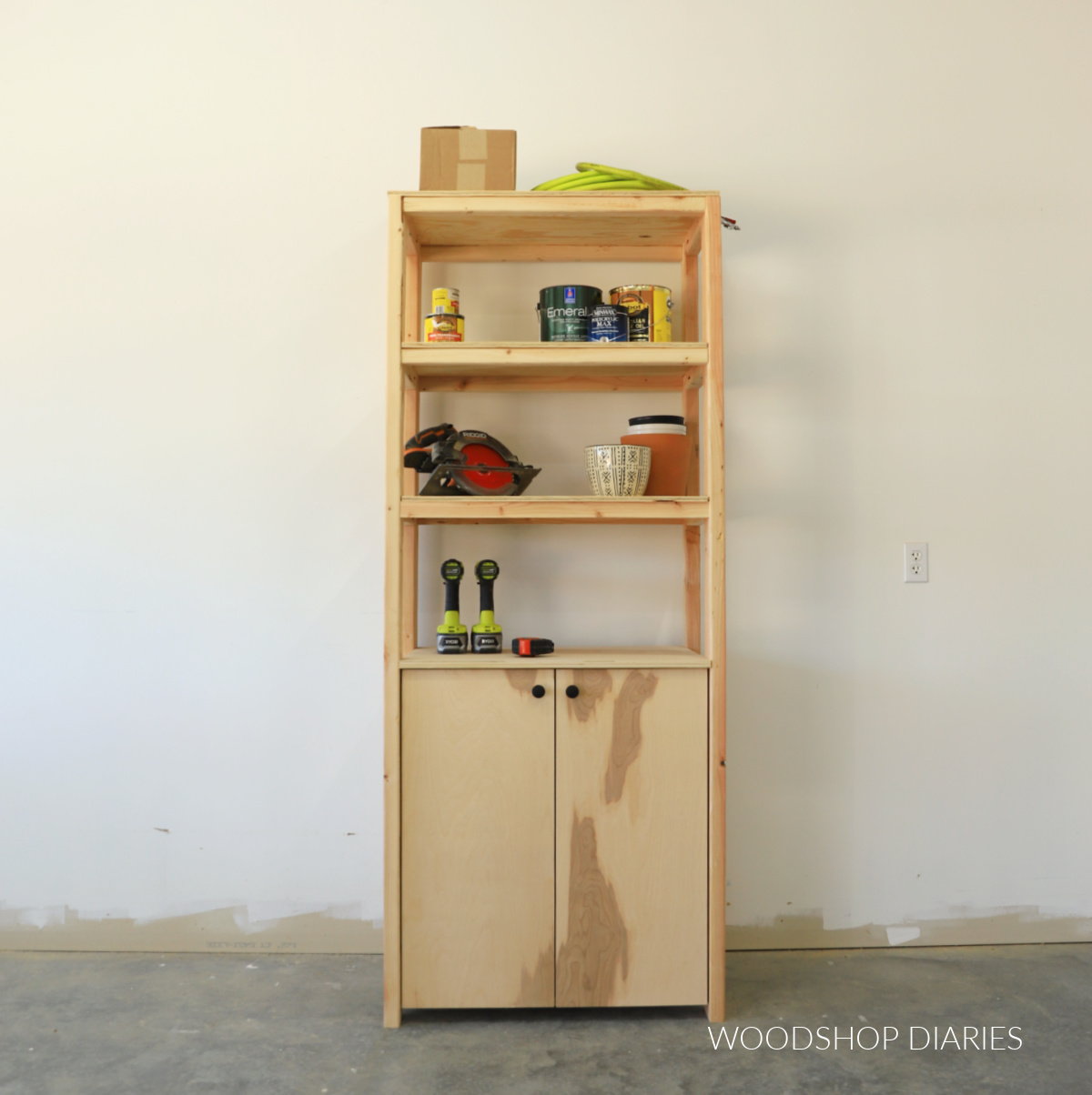Finished DIY garage shelf with cabinet on bottom and three shelves on top