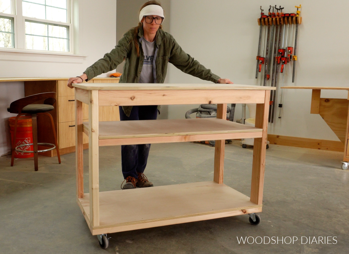 Shara Woodshop Diaries rolling completed workbench on casters before adding side storage