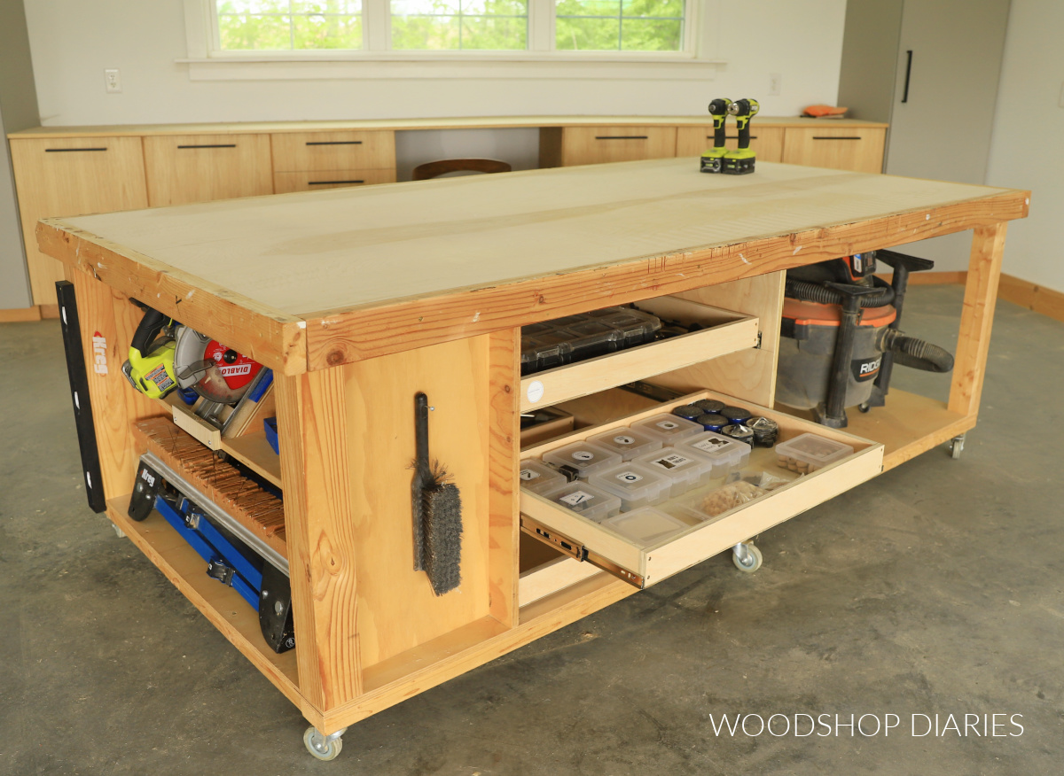 DIY large mobile workbench with storage in workshop--one drawer open to reveal containers for small parts storage