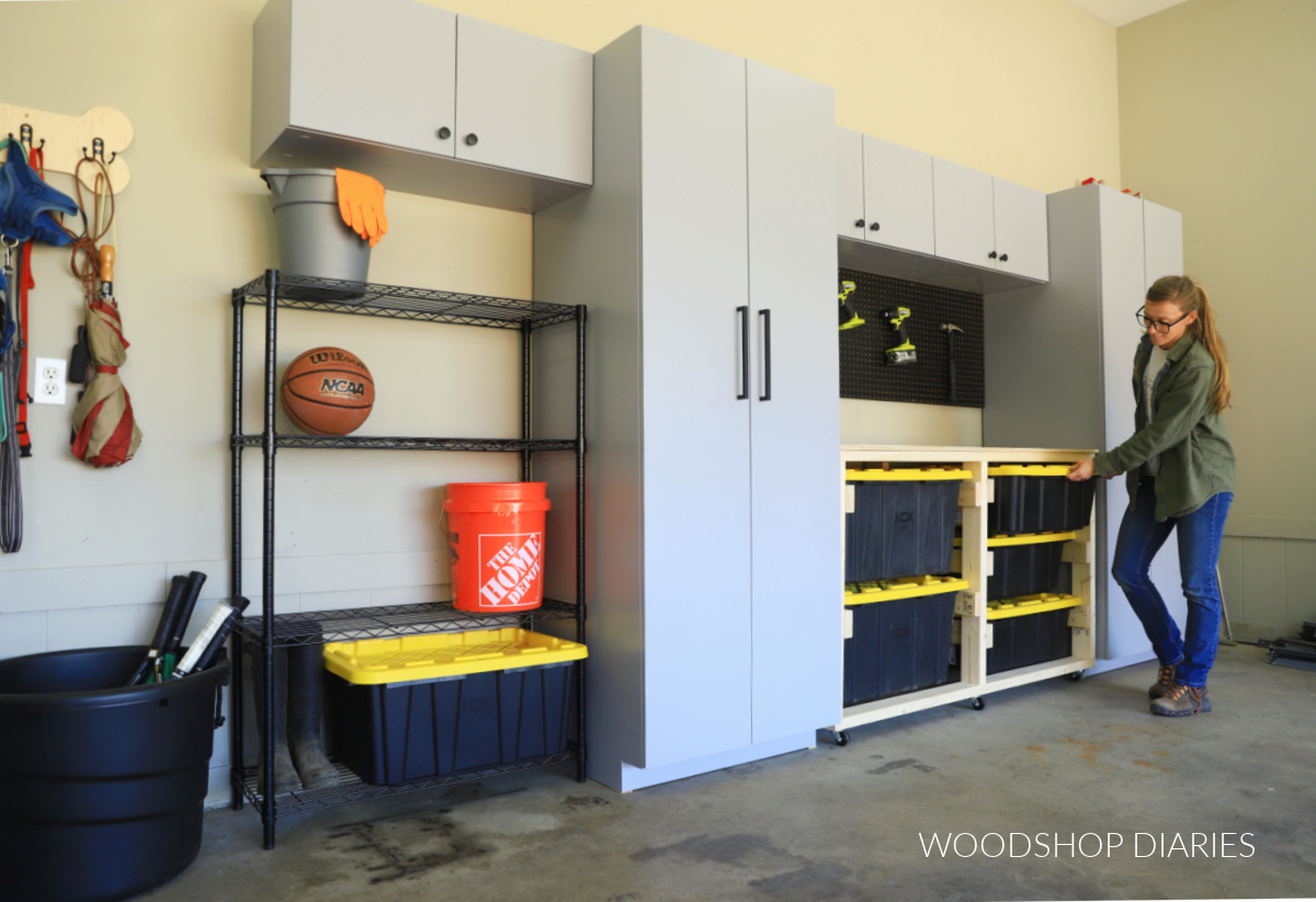 Shara Woodshop Diaries placing storage tote in storage tote workbench between gray garage cabinets
