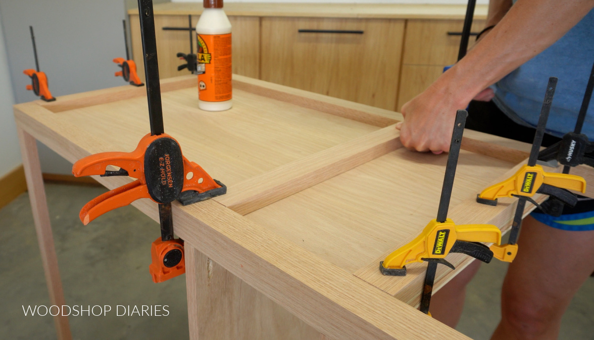 Shara Woodshop Diaries gluing 1x2 trim pieces onto sides of DIY bathroom vanity build