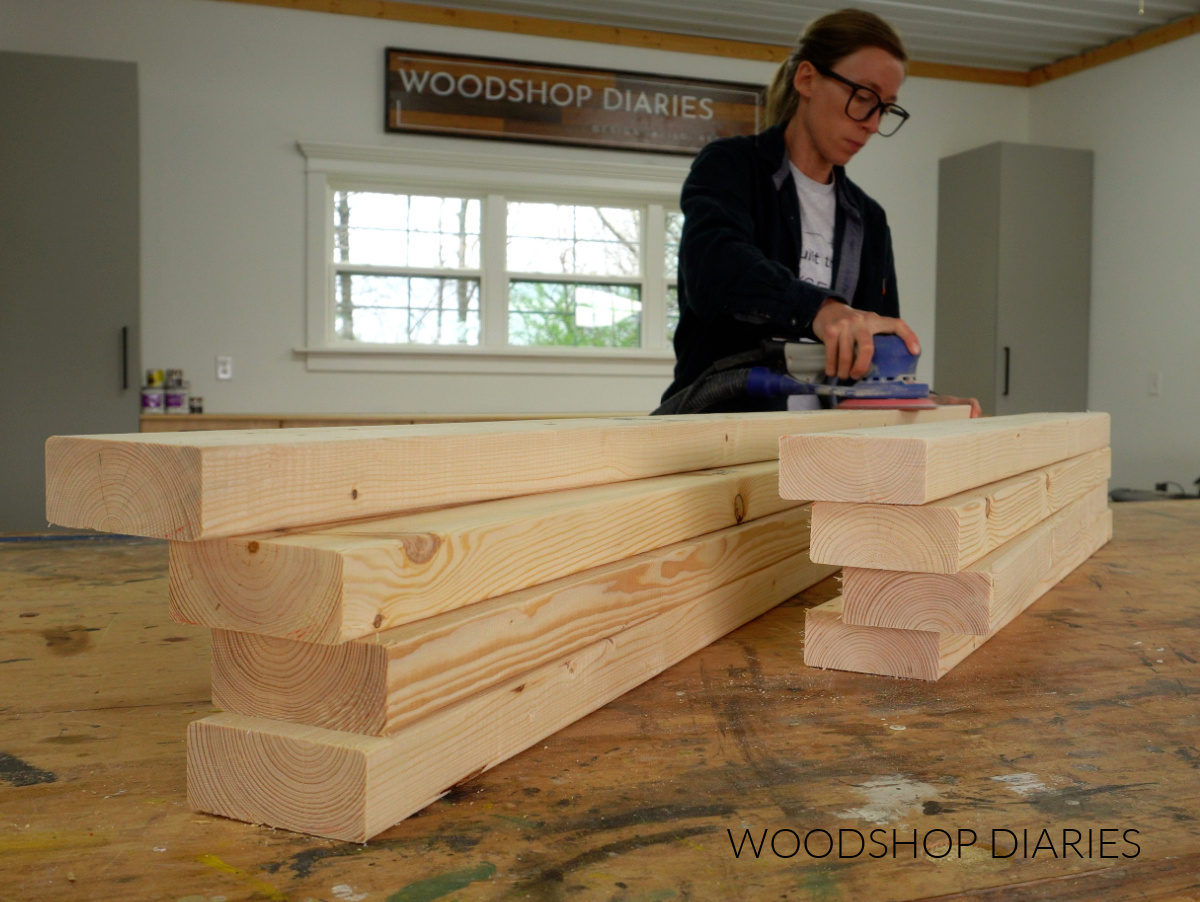 Shara Woodshop Diaries sanding 2x4 boards on workbench top