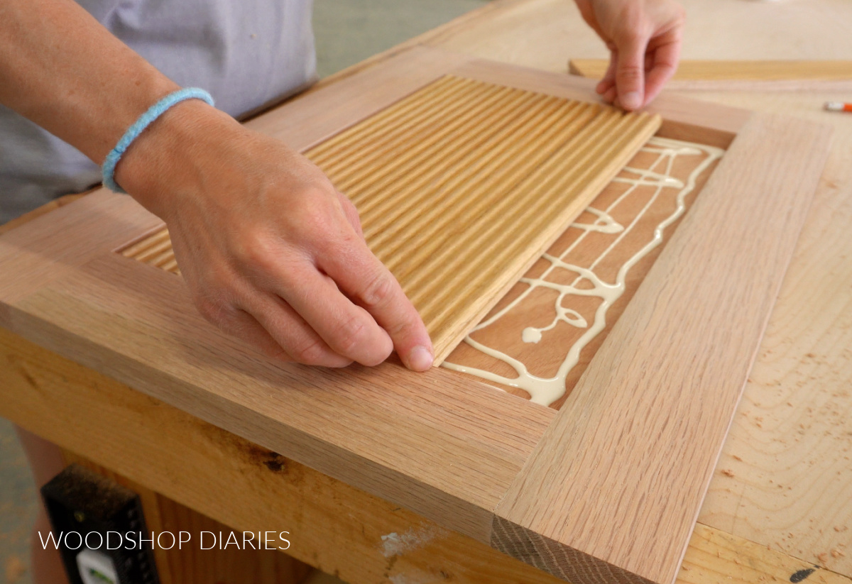 Shara Woodshop Diaries installing fluted trim pieces into door frame with glue