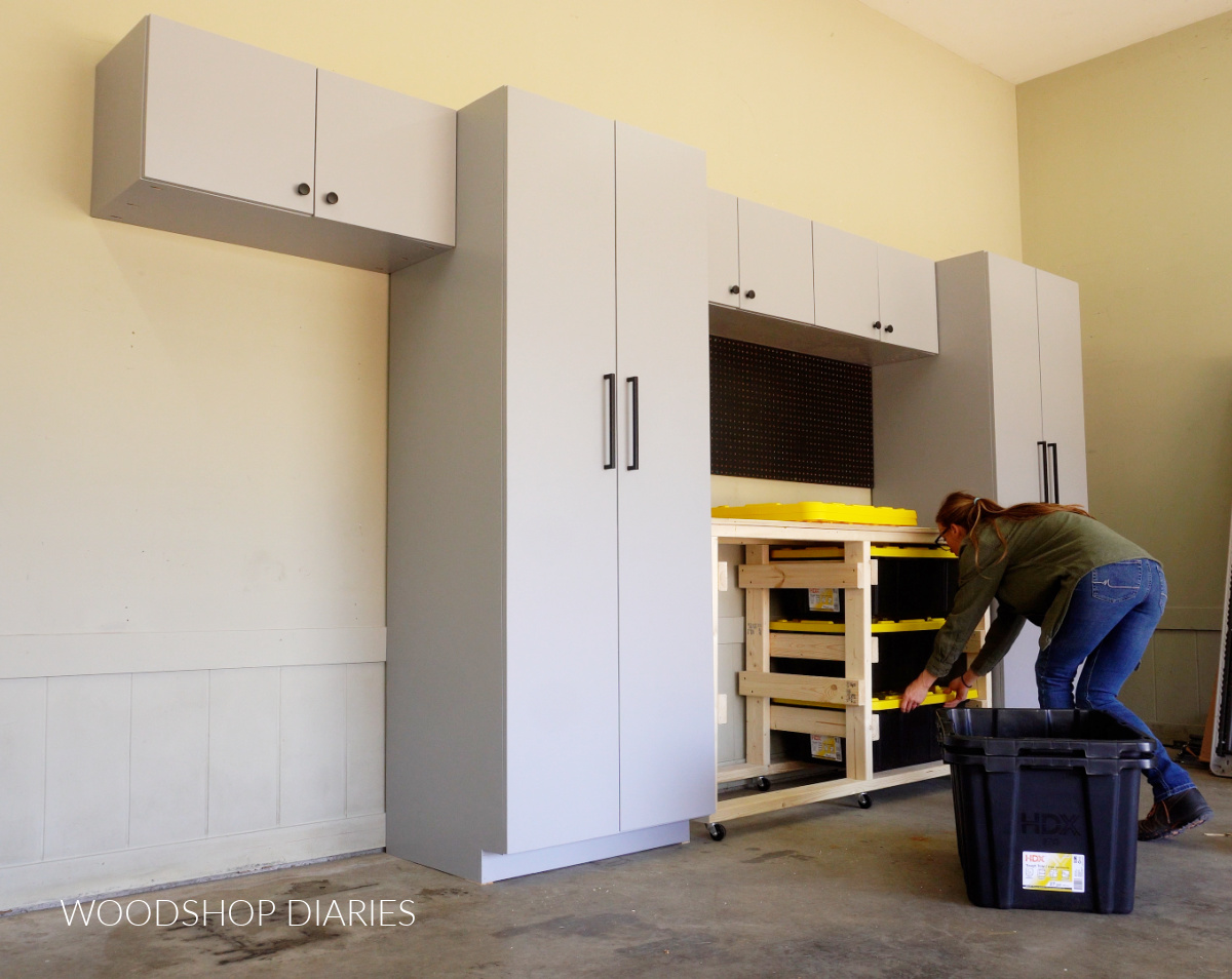 Garage cabinets installed with mobile workbench rolled into pace--Shara Woodshop Diaries installing storage totes into workbench