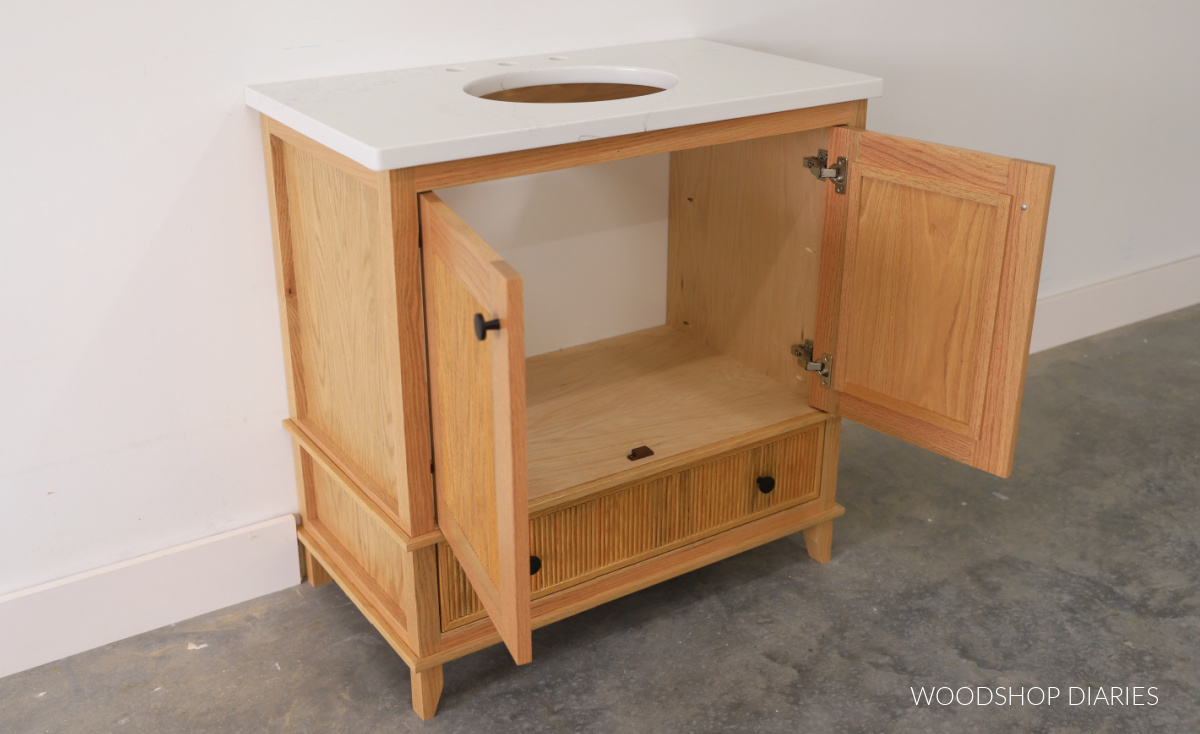 Simple sink sink bathroom vanity with fluted trim detail--double doors open in top section where plumbing will go