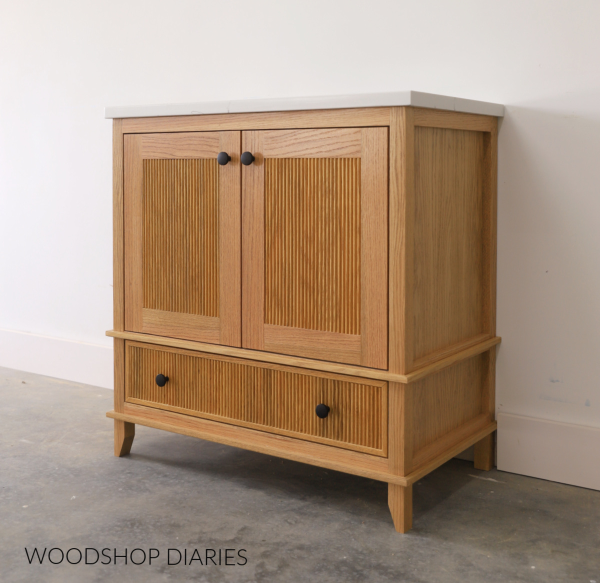 Small single sink bathroom vanity with fluted trim detail on the doors and drawer front--DIY bathroom vanity with trim