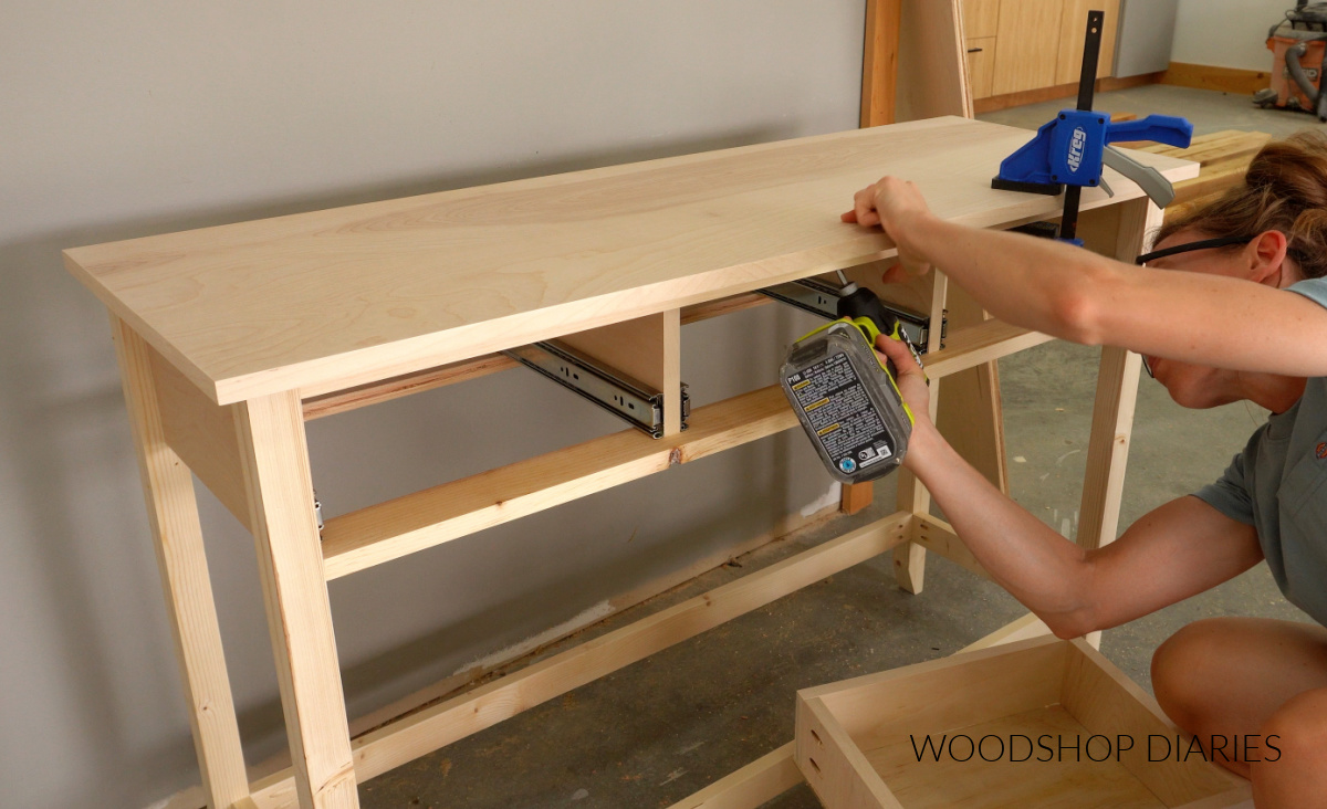 Shara Woodshop Diaries installing the top panel onto console table base using wood screws through top supports