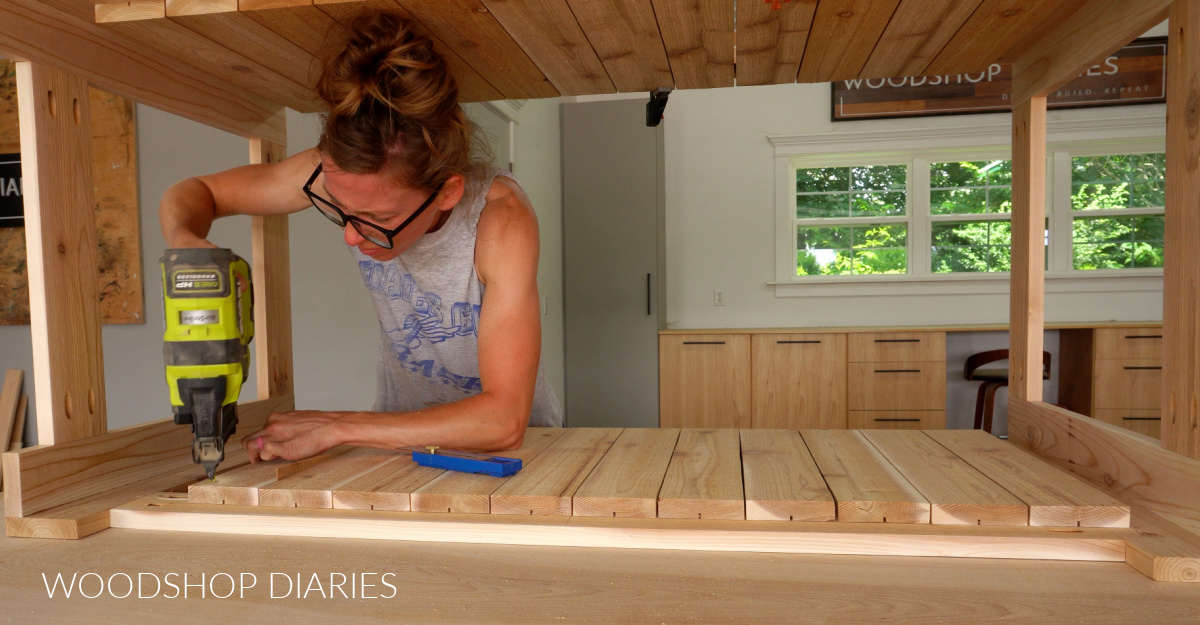 Shara Woodshop Diaries nailing slats onto long sides of outdoor box