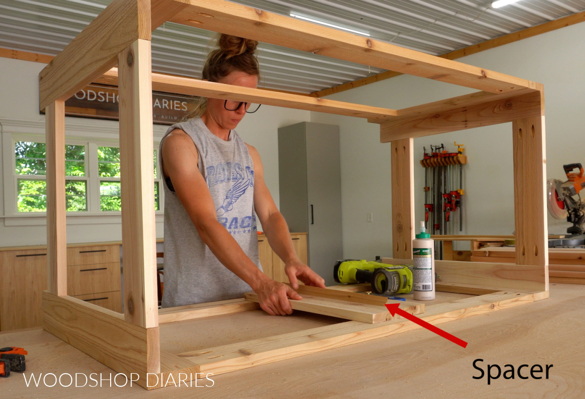Shara Woodshop Diaries installing slats on sides of outdoor storage box with a spacer block