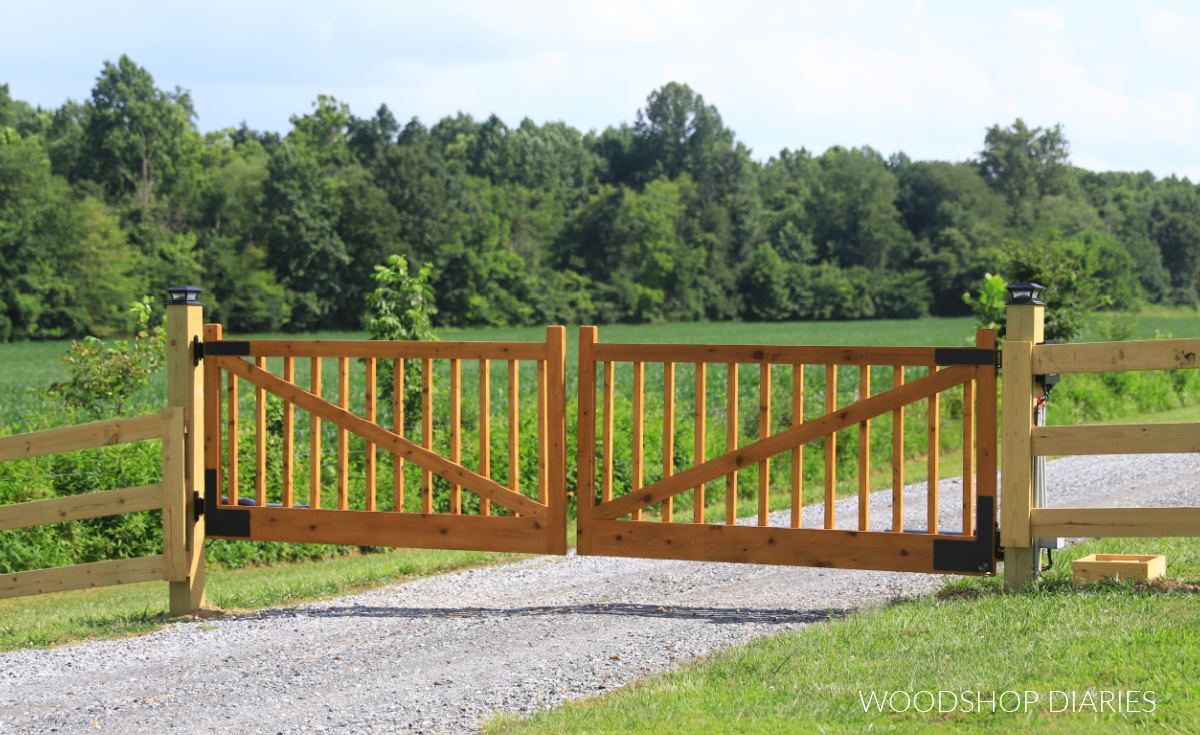 DIY wooden driveway gates closed across gravel driveway with wooden fence on each side