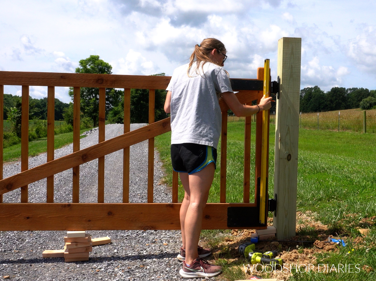 Shara Woodshop Diaries checking that gate is level before installing onto post