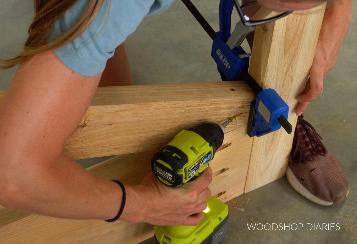 Shara Woodshop Diaries securing diagonal brace of large wooden gate with screws