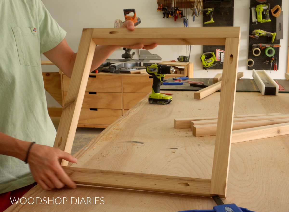 Shara Woodshop Diaries holding up 2x2 umbrella table frame assembled with pocket holes and screws