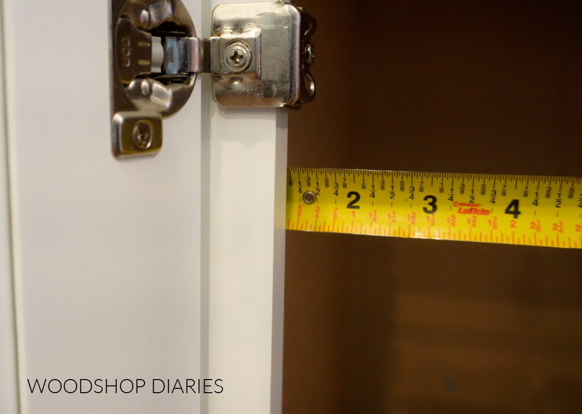 Close up of tape measure measuring face frame overhang on kitchen cabinet