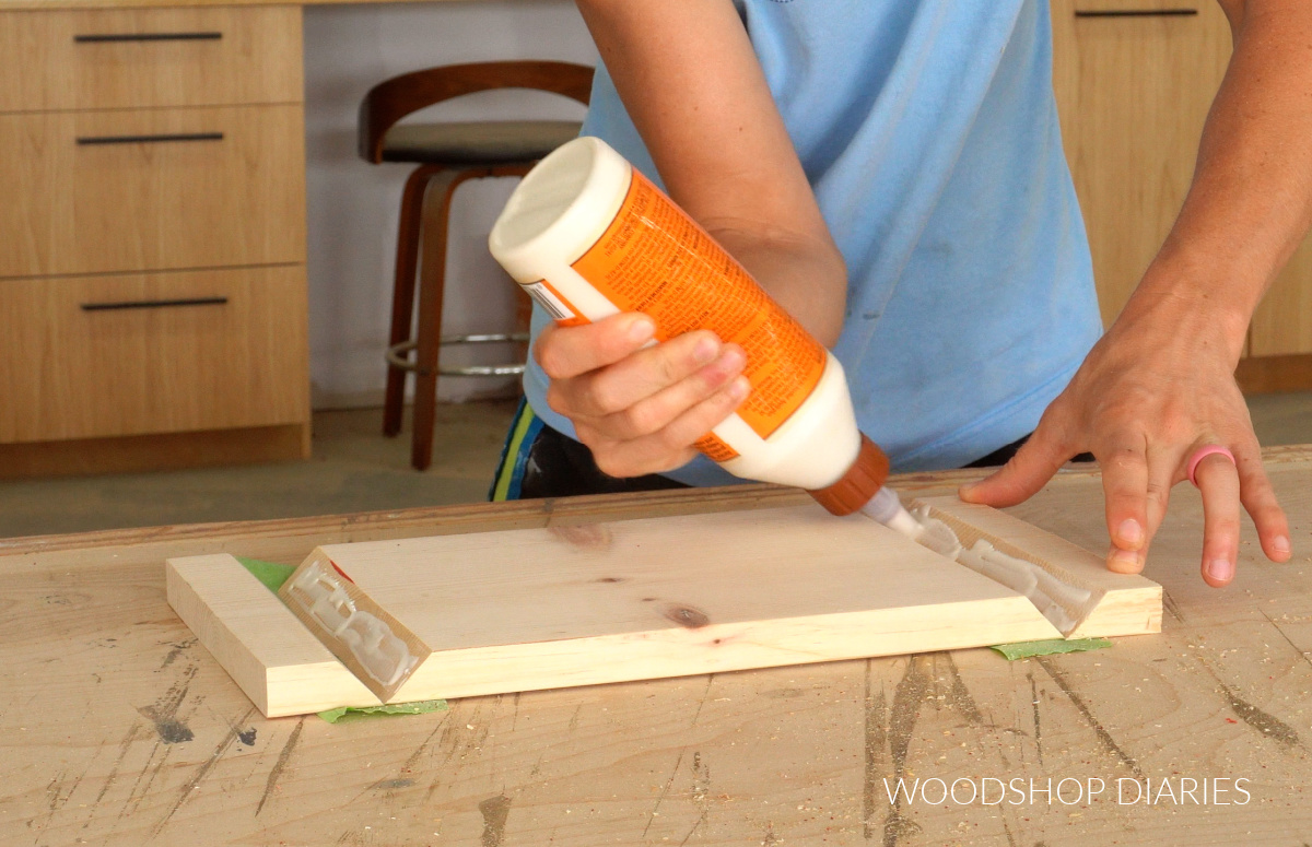 Shara Woodshop Diaries applying wood glue to beveled joints of wooden riser