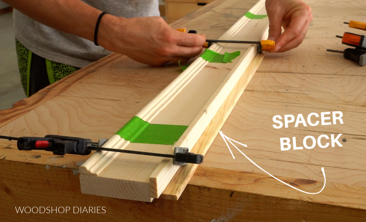 Gluing lattice trim on edge of 1x3 with spacer block on workbench