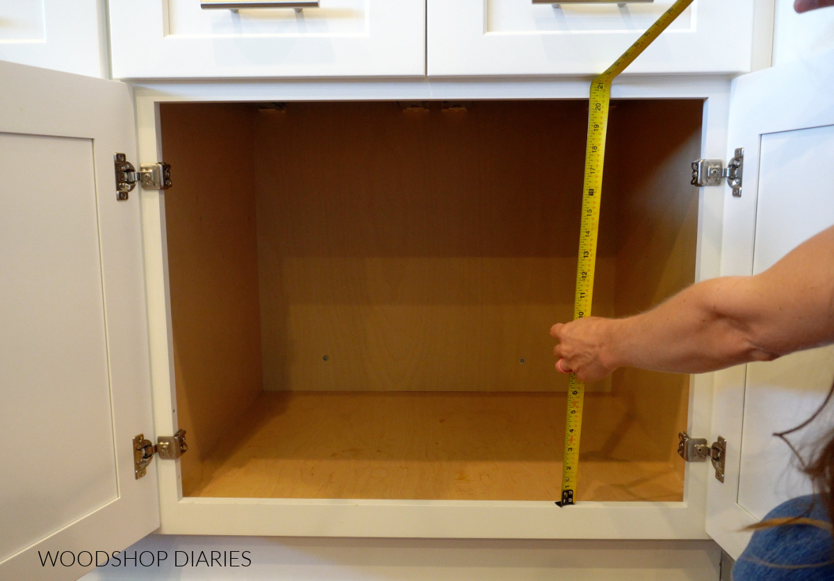 Measuring tape measuring height of base cabinet opening