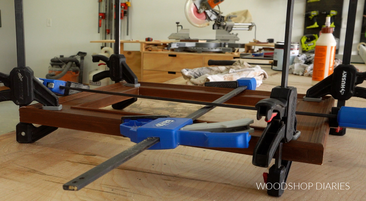 Using clamps to hold picture frame together while glue dries