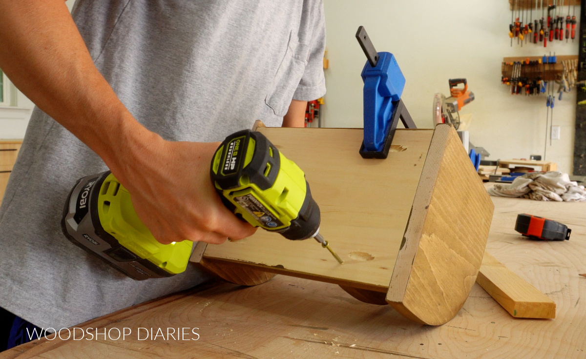 Close up of driving screws through bottom of desk organizer to attach dividers