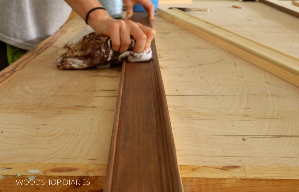 Applying wood stain to picture frame board with a rag