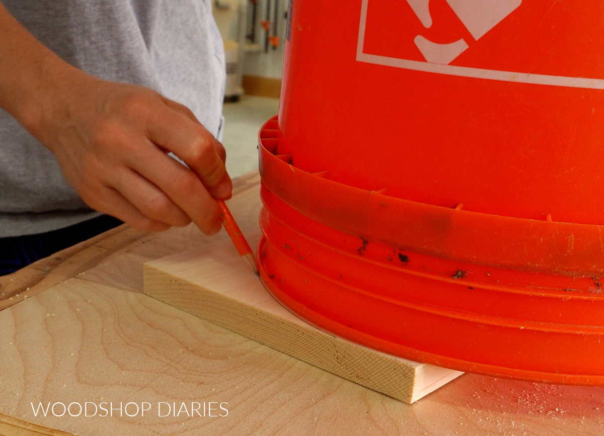 Shara Woodshop Diaries tracing curve on board using 5 gallon bucket