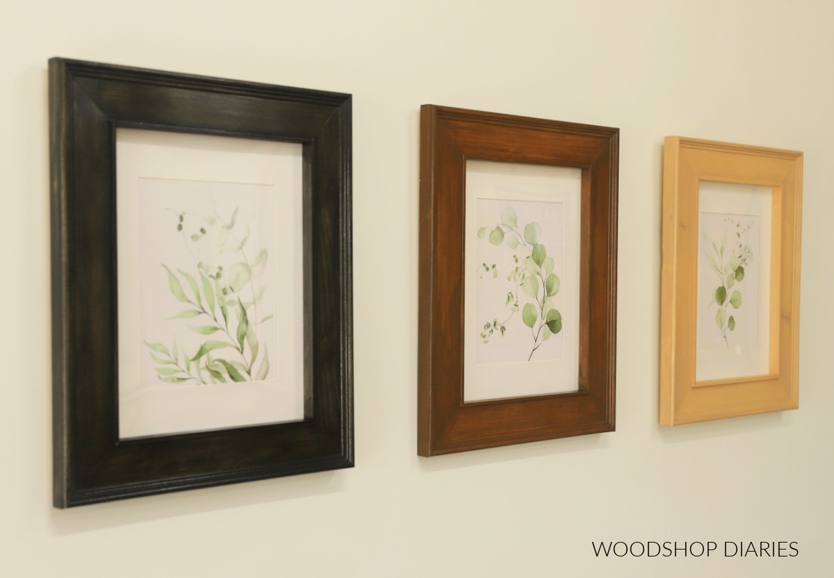 Three different color wooden picture frames hanging on wall