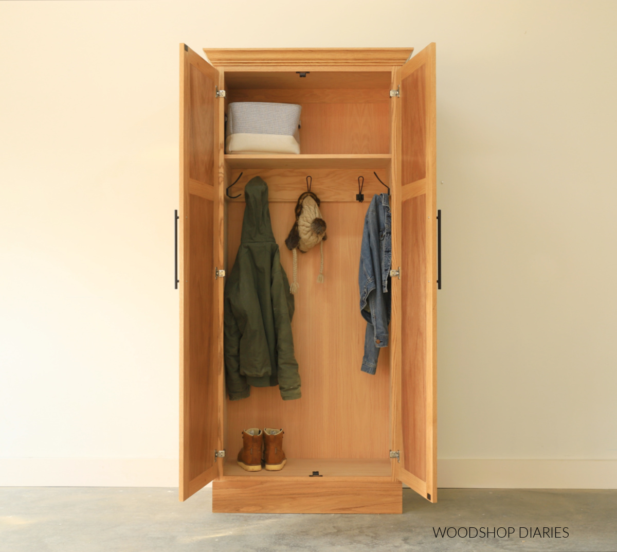 DIY coat storage cabinet armoire with double doors open to reveal inside with hooks and shelf and shoe storage
