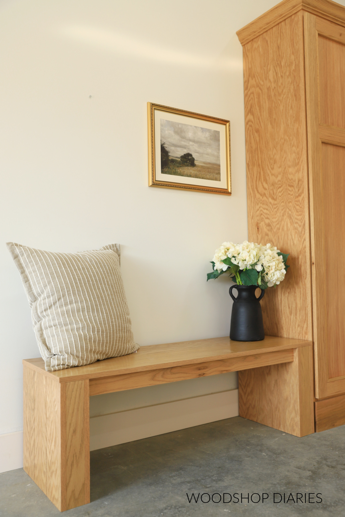Close up of modern chunky style DIY freestanding bench with kerfs cut on side panels next to tall cabinet