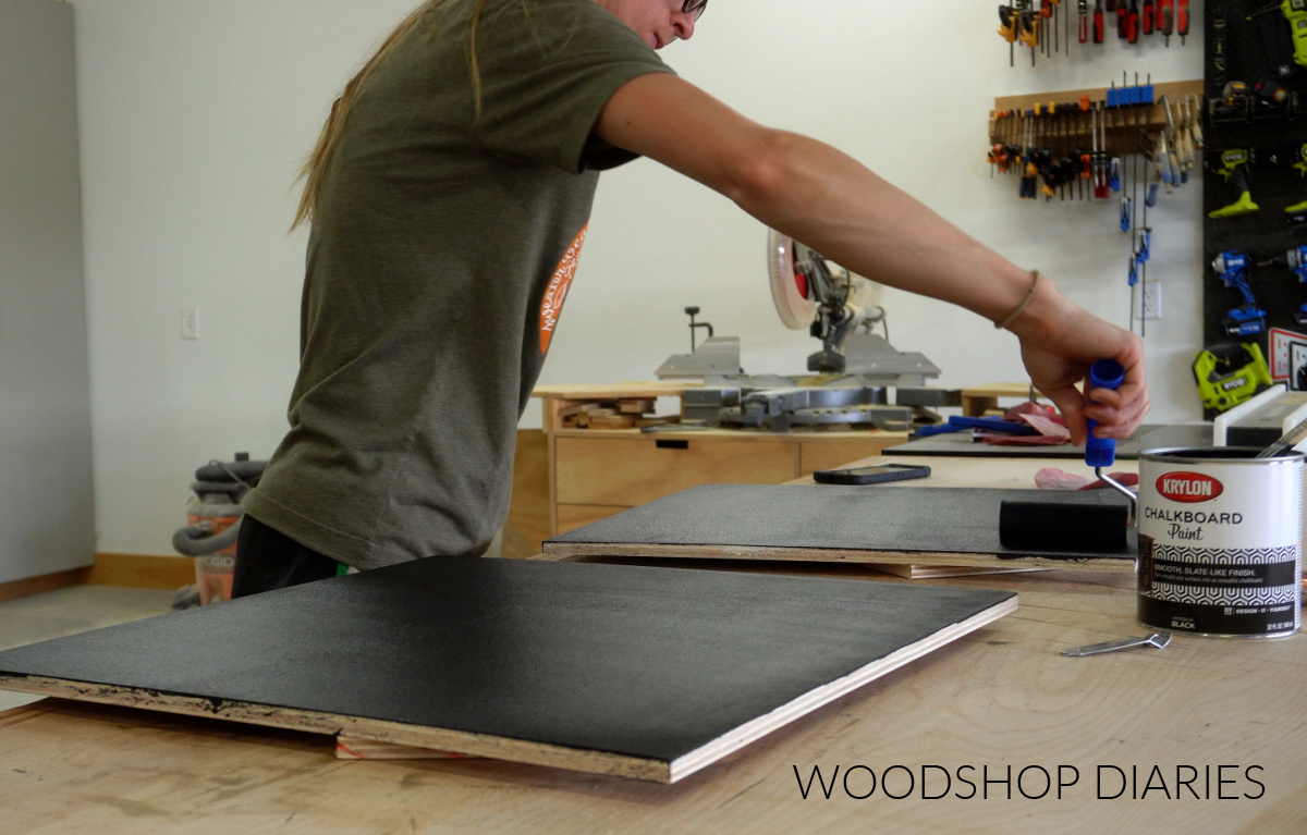 Shara Woodshop Diaries painting plywood canvases with chalkboard paint on workbench
