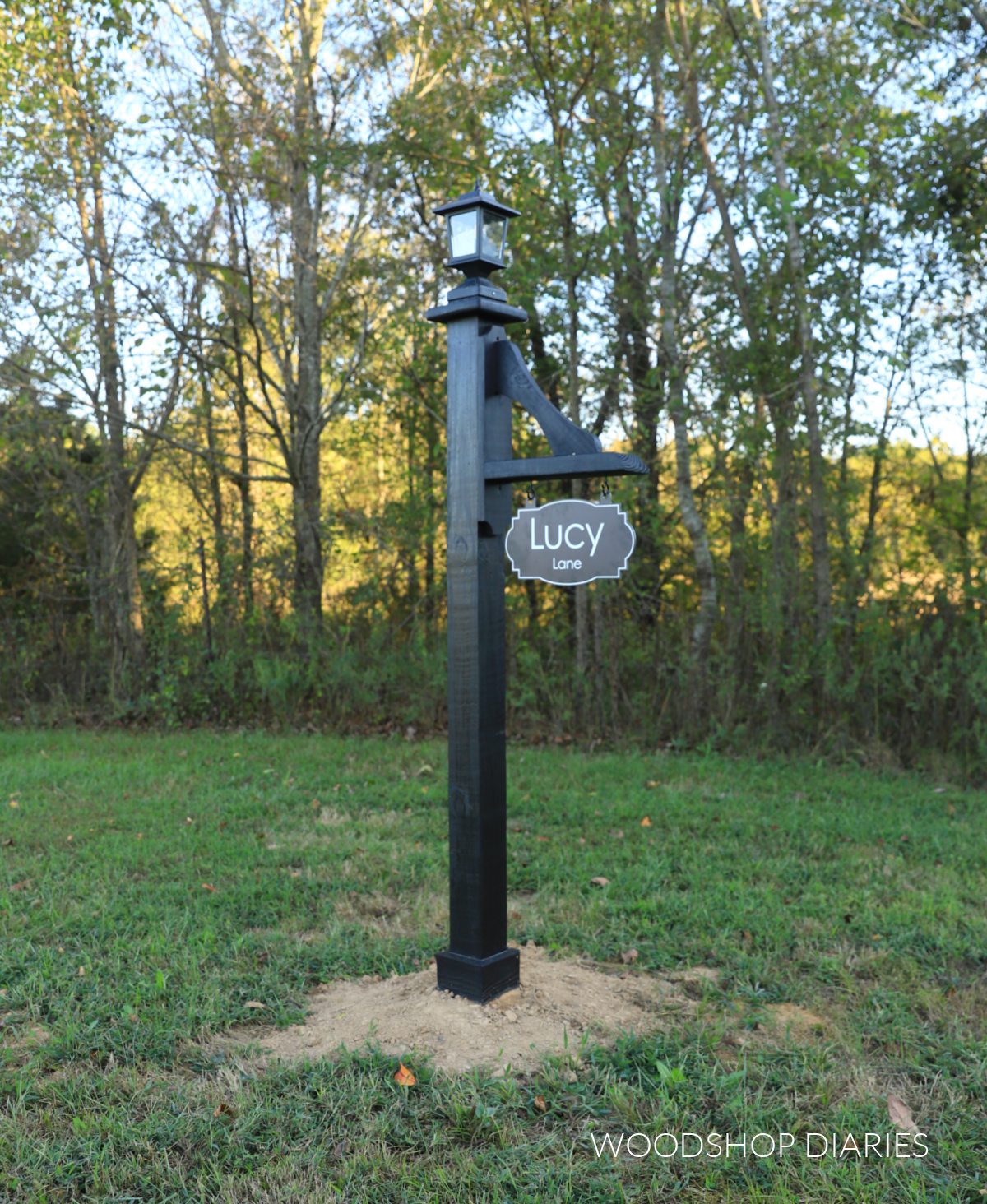 black wooden lamp post with address sign and solar lantern