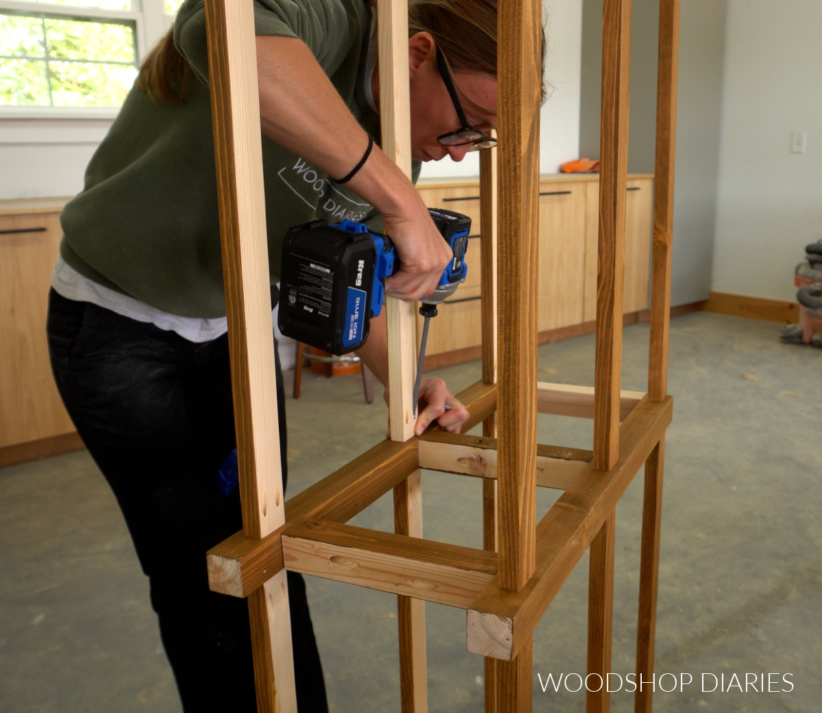 Close up of Shara Woodshop Diaries driving pocket hole screws to assemble console base frame
