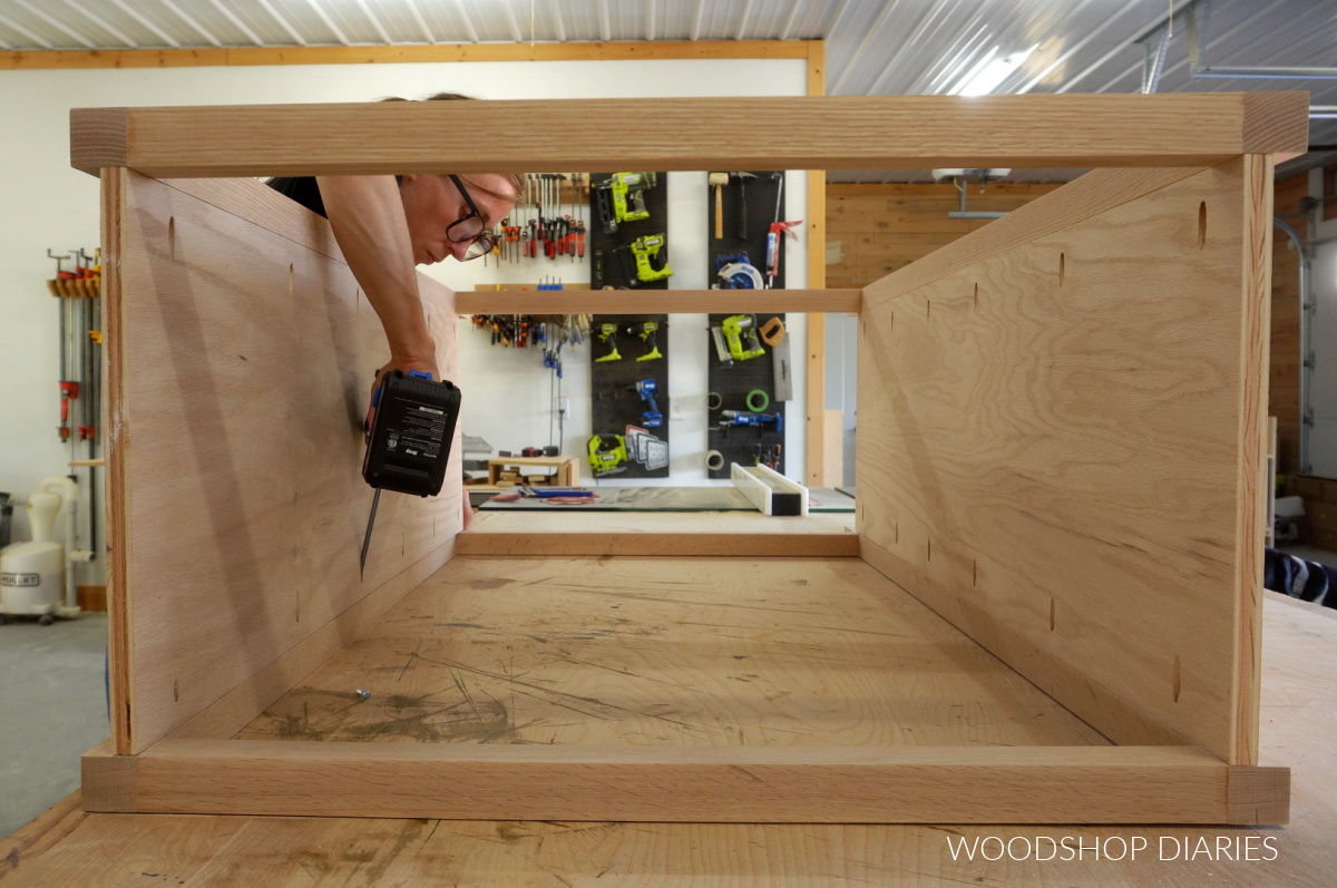 Shara Woodshop Diaries attaching side panels of chest of drawers on workbench with pocket holes